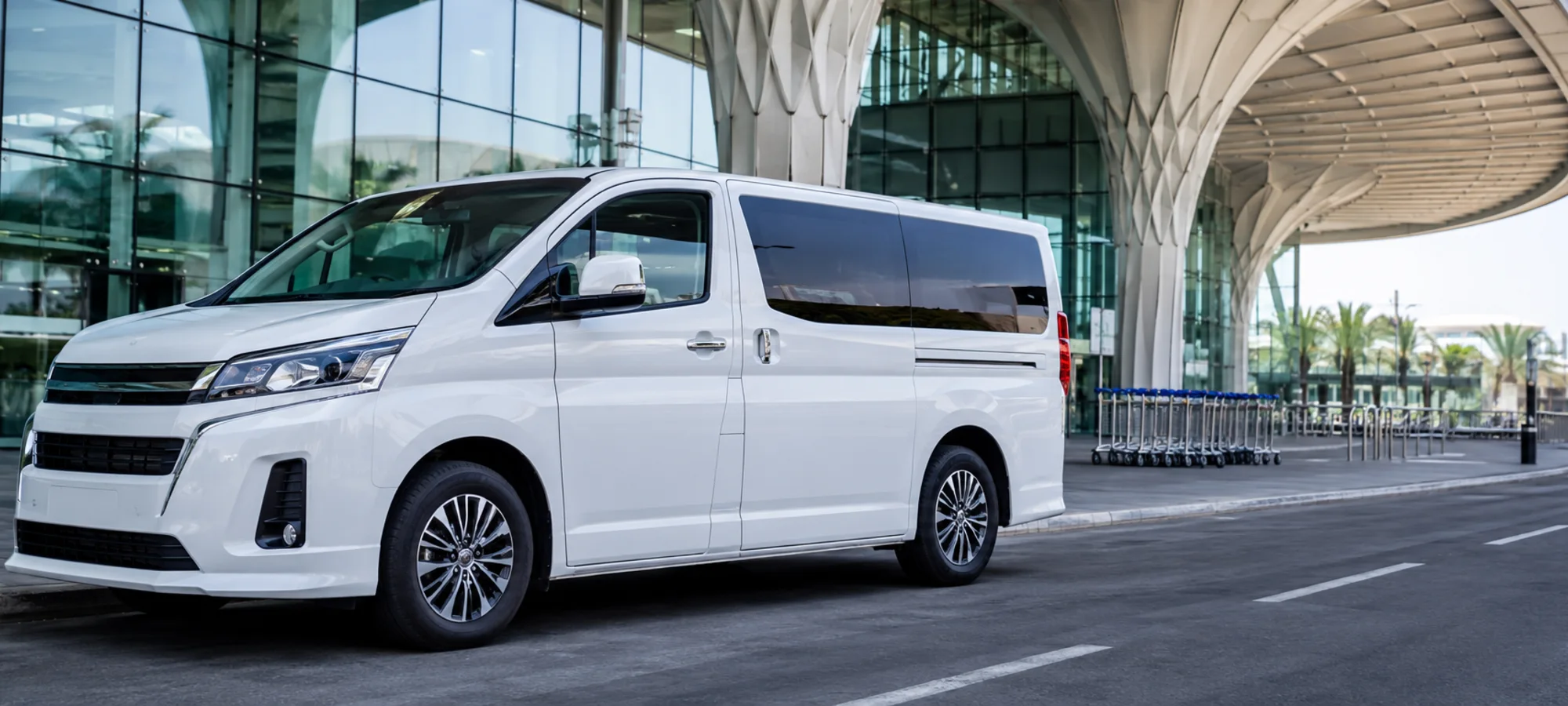 Executive passenger van ready for an airport transfer at a modern UAE terminal